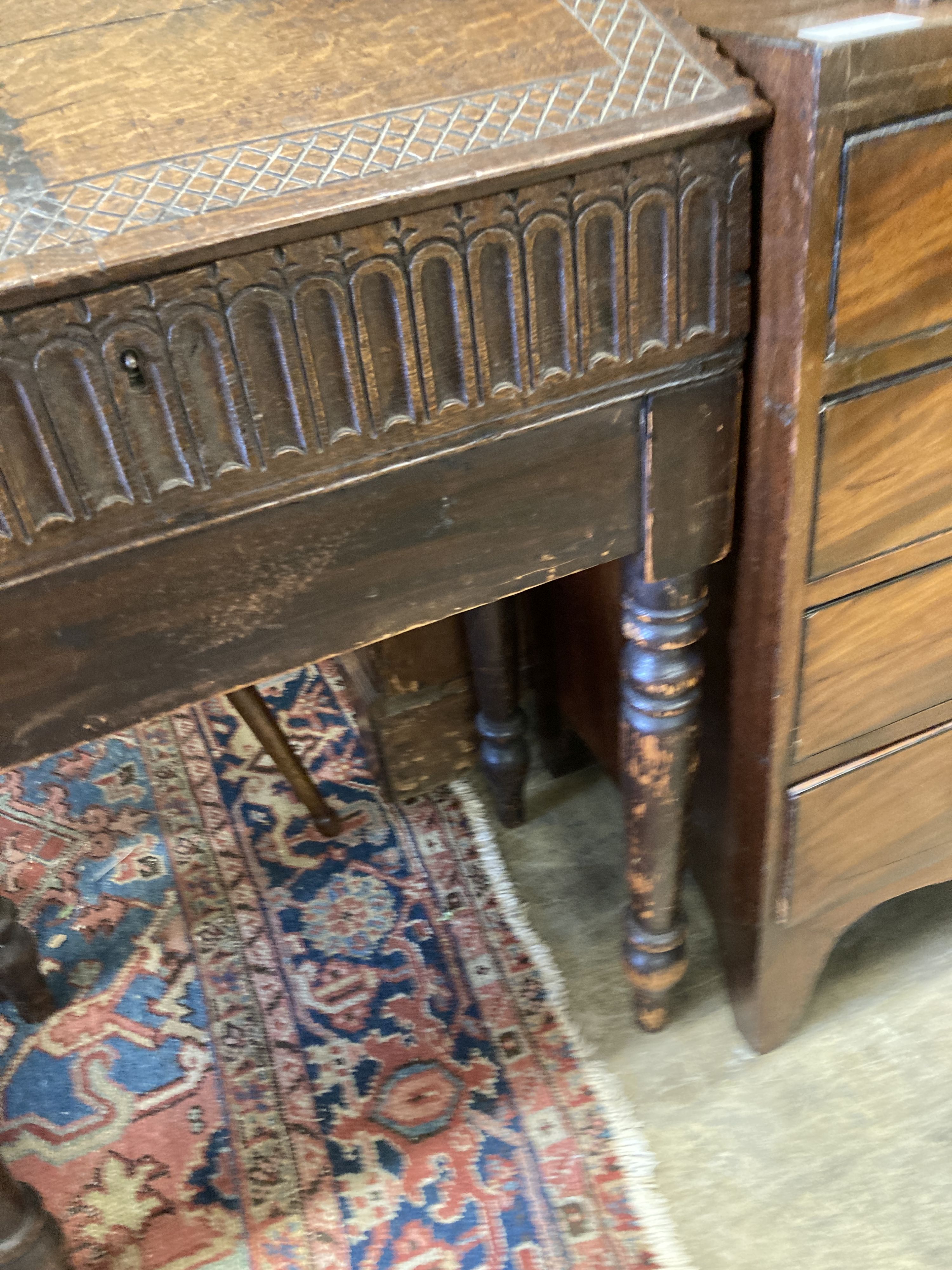 A 17th century oak slant front bible box, raised on a stand